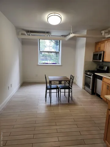 a view of a room with kitchen wooden floor and windows