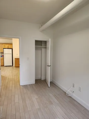 a view of a room with wooden floor and brick walls