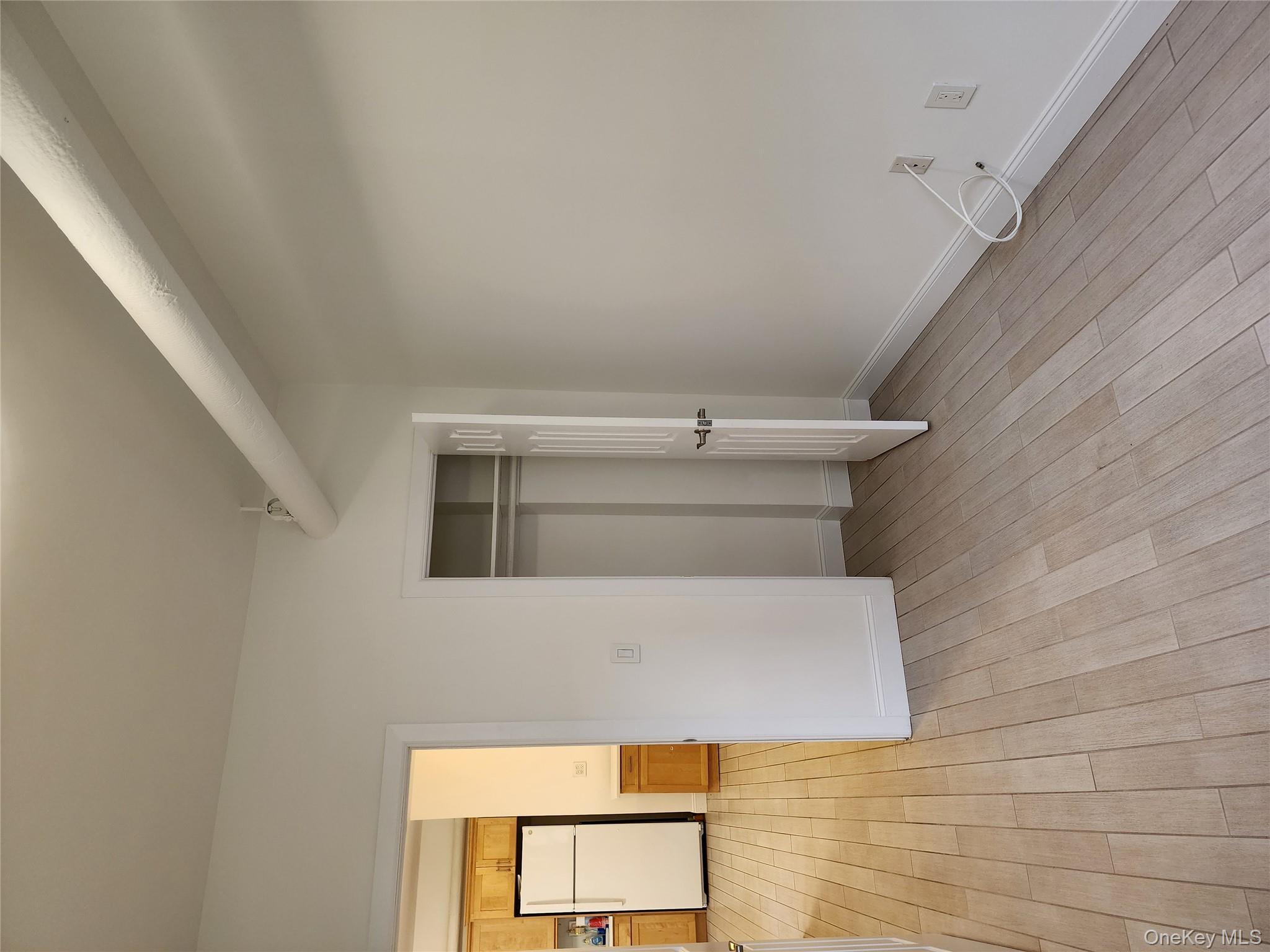 30-47 Hobart Street, Unit DDB Queens, NY 11377 - Photo 19 of 25 a view of a room with wooden floor and brick walls