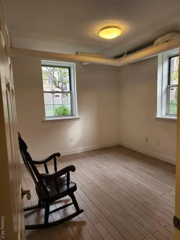 a view of a room with wooden floor a ceiling fan and windows
