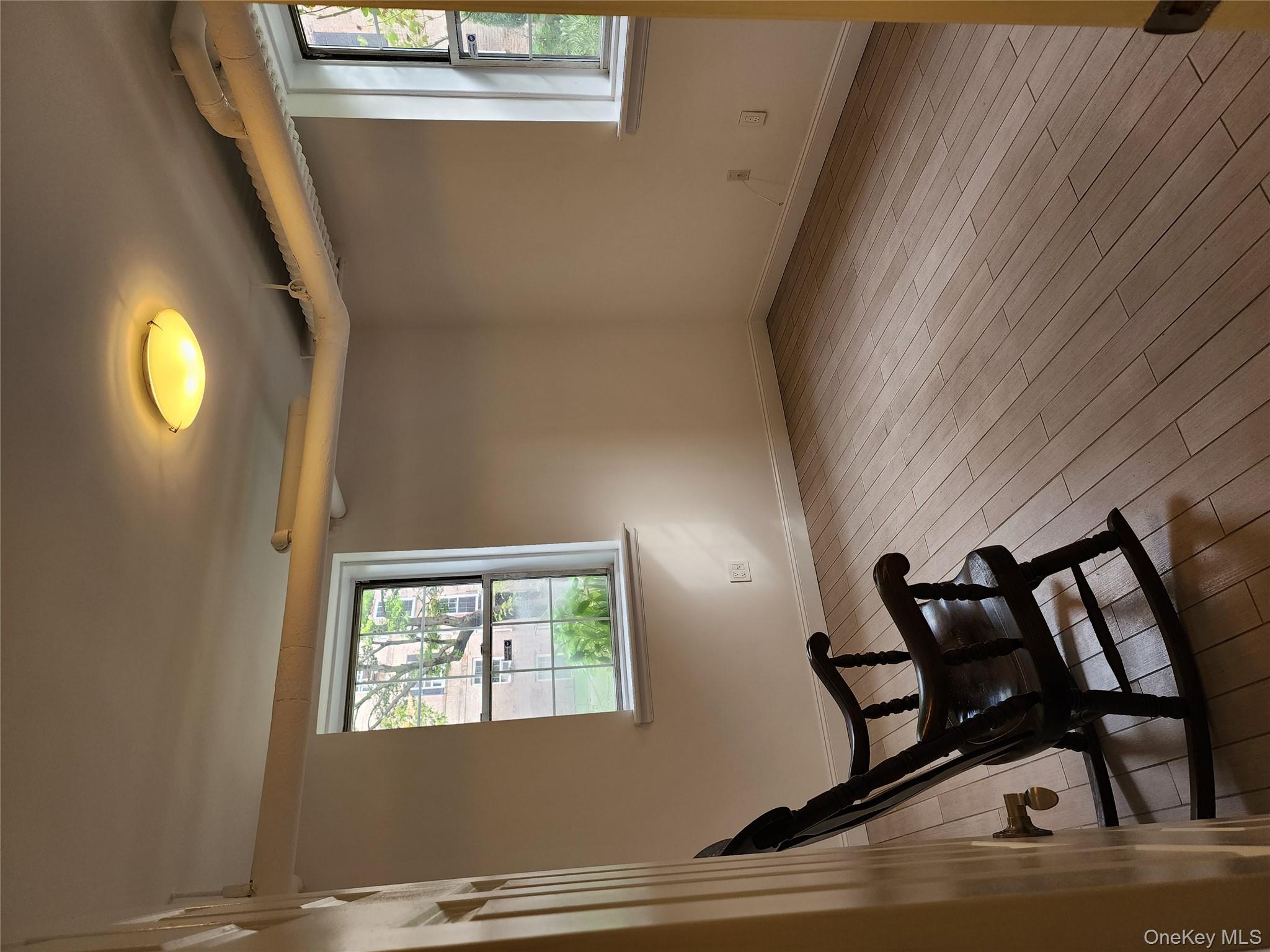 30-47 Hobart Street, Unit DDB Queens, NY 11377 - Photo 20 of 25 a view of a room with wooden floor a ceiling fan and windows