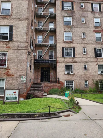 a front view of a building with a garden and plants