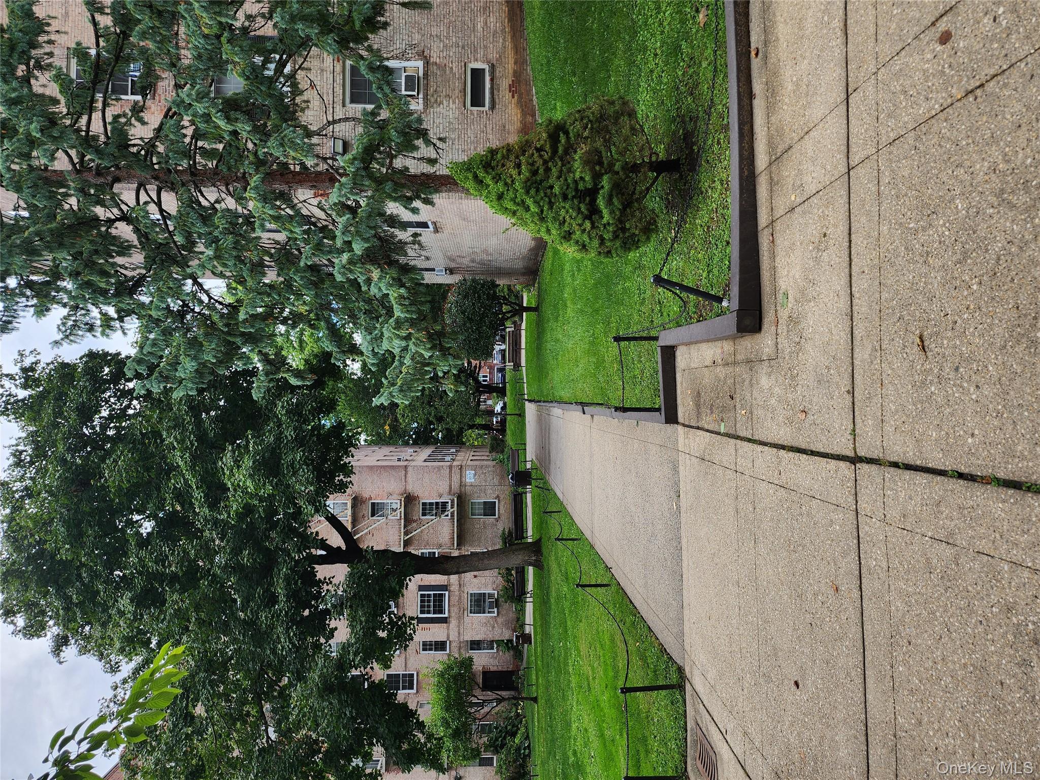 30-47 Hobart Street, Unit DDB Queens, NY 11377 - Photo 5 of 25 a front view of a house with a yard and a garage