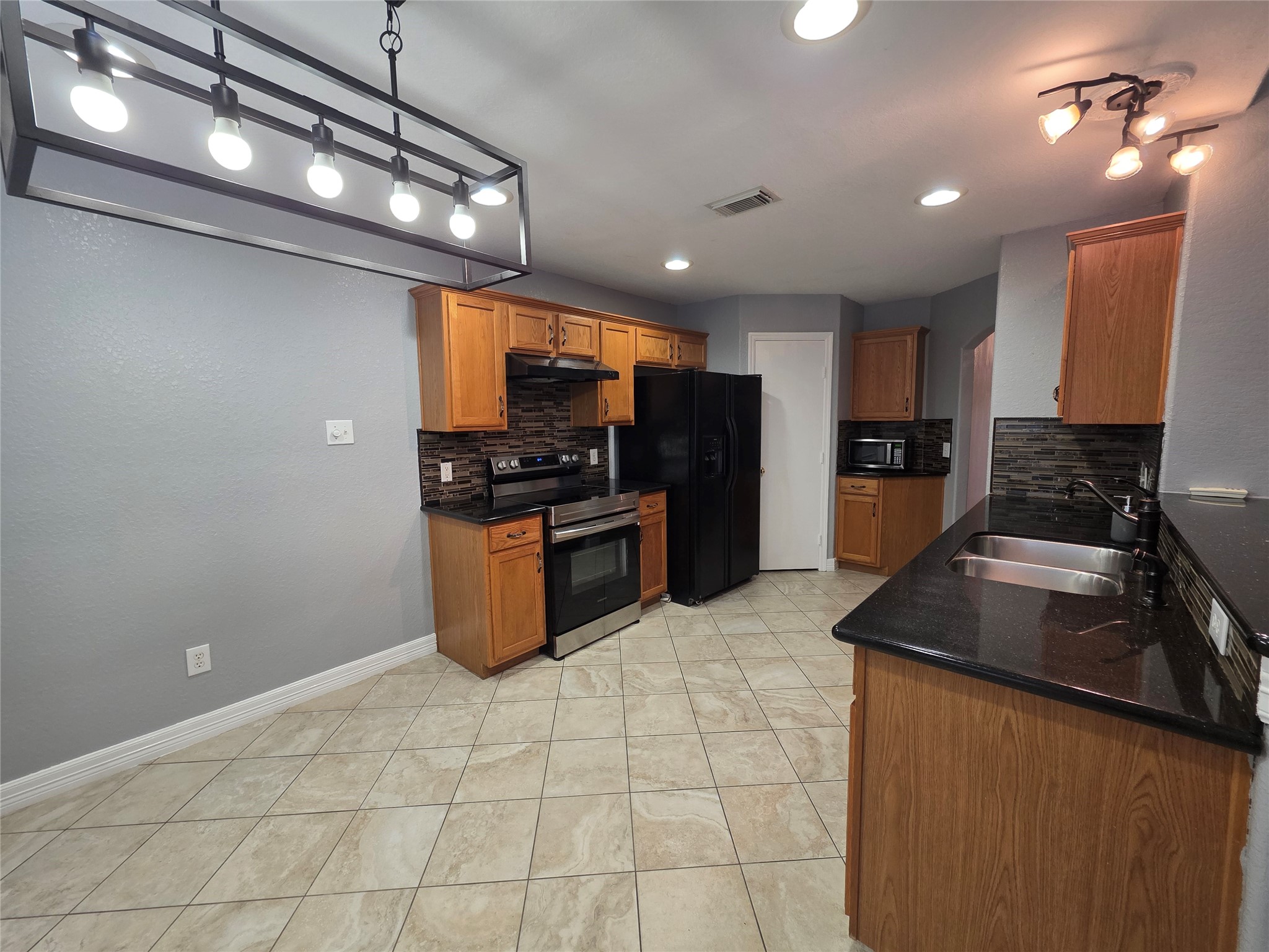 5614 Eagle Landing Houston, TX 77085 - Photo 6 of 28 a kitchen with stainless steel appliances granite countertop a sink a stove top oven a counter space and cabinets