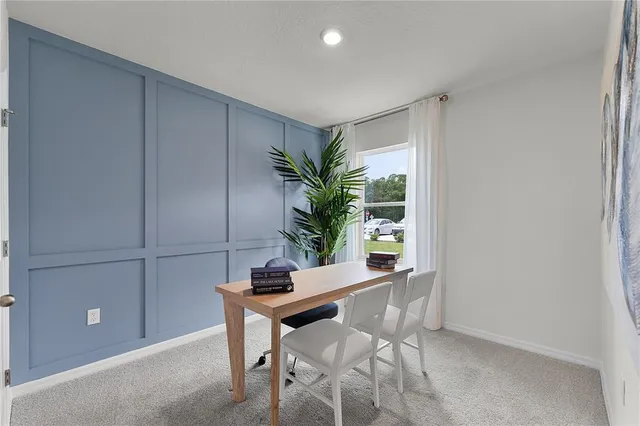 a bedroom with a bed painting on the wall and a potted plant