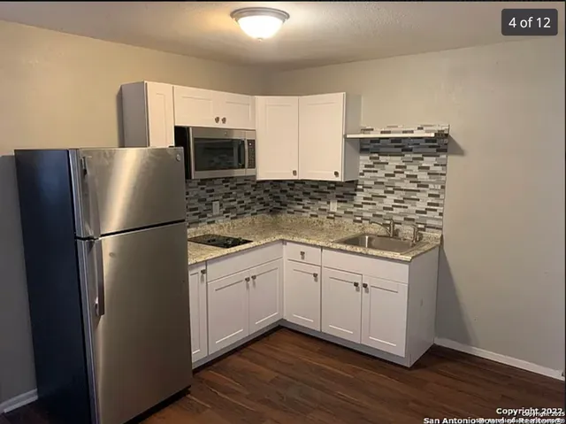 a kitchen with stainless steel appliances granite countertop a refrigerator sink and microwave