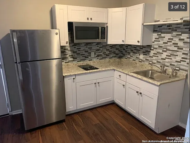 a kitchen with stainless steel appliances a refrigerator sink and microwave