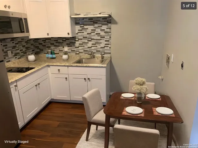 a kitchen that has a sink and chairs in it