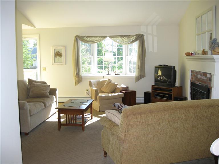 52 Clark Road Brewster, MA 02631 - Photo 8 of 32 a living room with furniture a large window and a fireplace