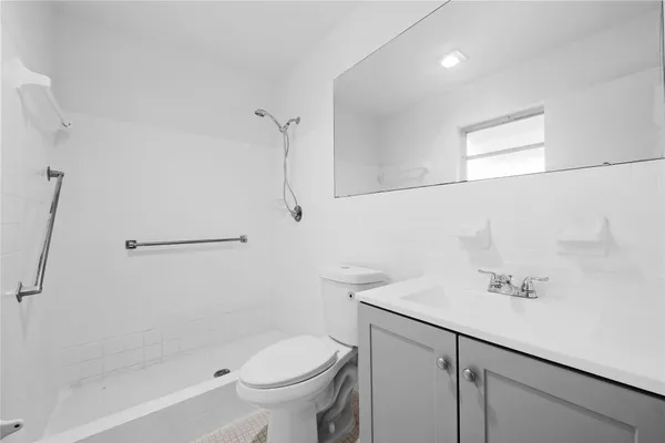 a bathroom with a sink a toilet and shower