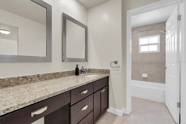 a bathroom with a granite countertop sink and a mirror