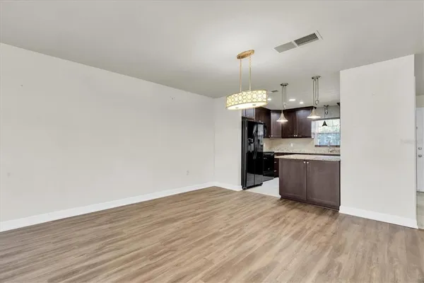 a kitchen with stainless steel appliances a sink cabinets and wooden floor