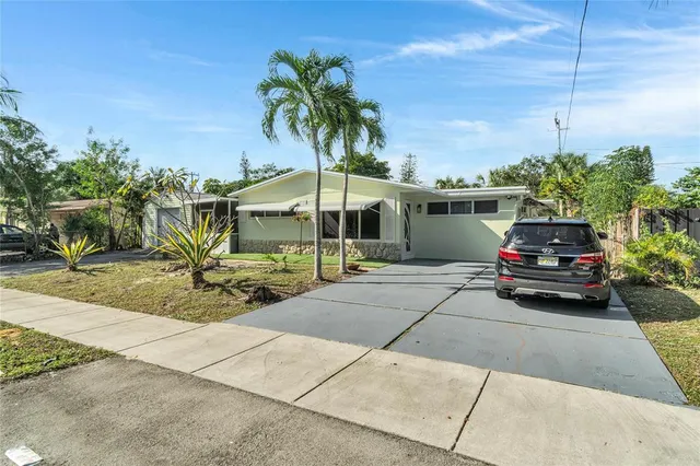 a house view with a sitting space and palm trees
