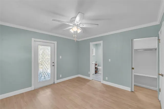 a view of an empty room with chandelier fan