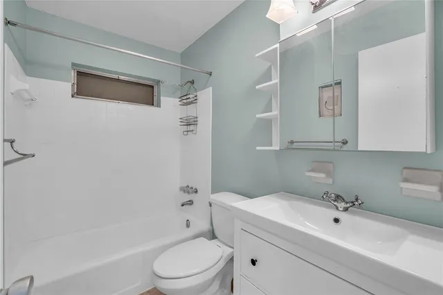 a bathroom with a toilet a sink a mirror and bathtub