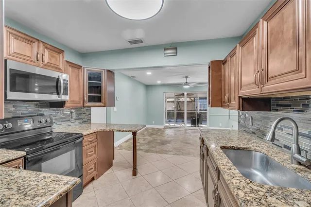 a kitchen with stainless steel appliances granite countertop a sink stove and microwave