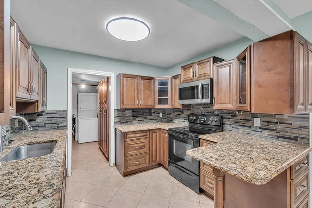 a kitchen with stainless steel appliances granite countertop a sink stove and cabinets
