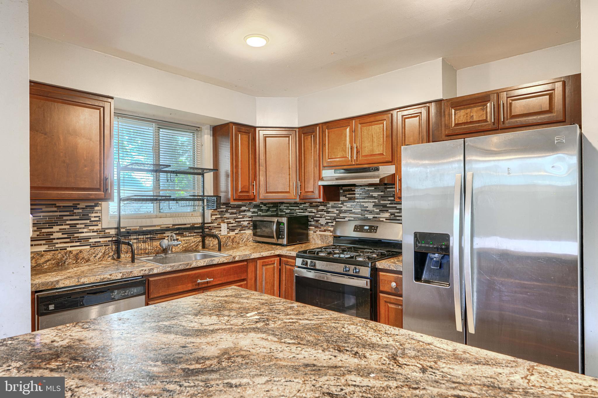 9706 Liberty Road Randallstown, MD 21133 - Photo 18 of 43 a kitchen with stainless steel appliances granite countertop a refrigerator sink and stove