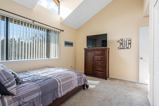 a bedroom with a bed and painting on the wall