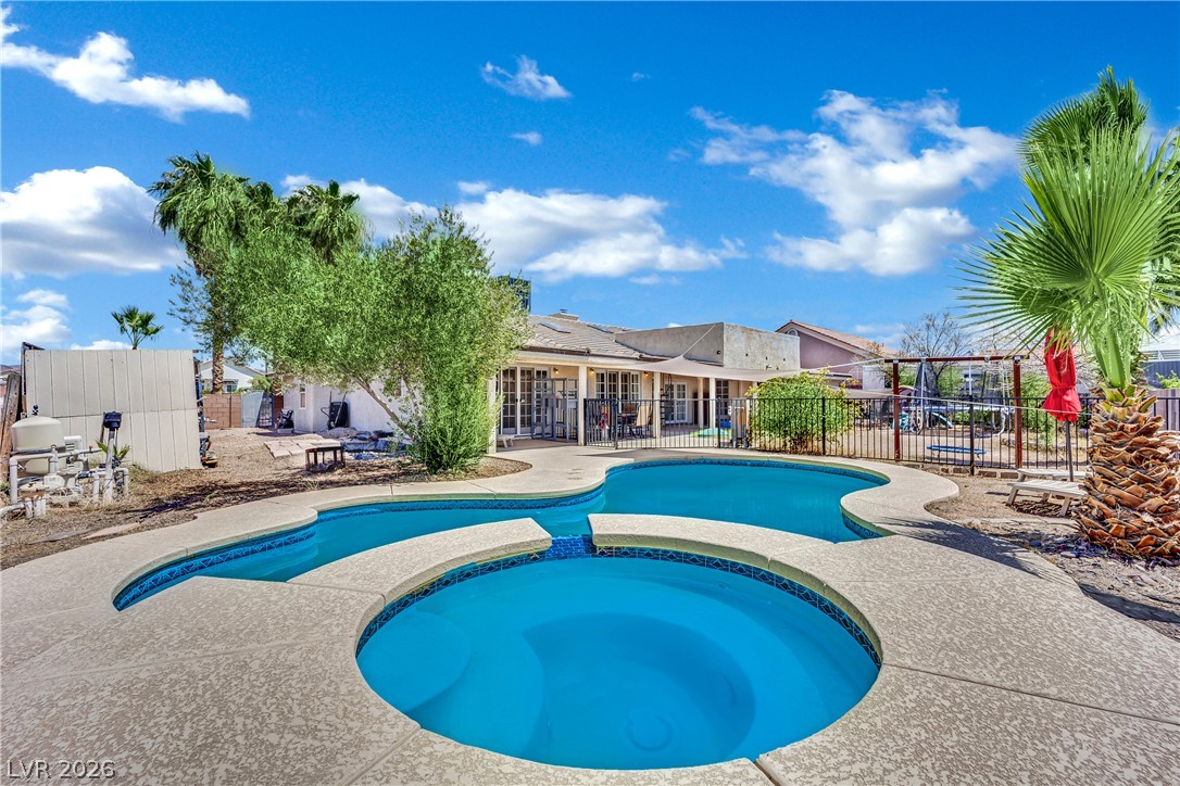 420 North Racetrack Road Henderson, NV 89015 - Photo 45 of 52 A spacious backyard oasis features a free-form pool and integrated spa, perfect for relaxation and entertaining.