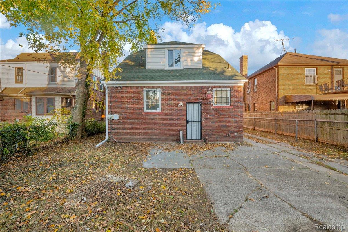 16717 Fielding Street Detroit, MI 48219 - Photo 46 of 46 Rear view of house featuring brick siding, a fenced backyard, and roof with shingles