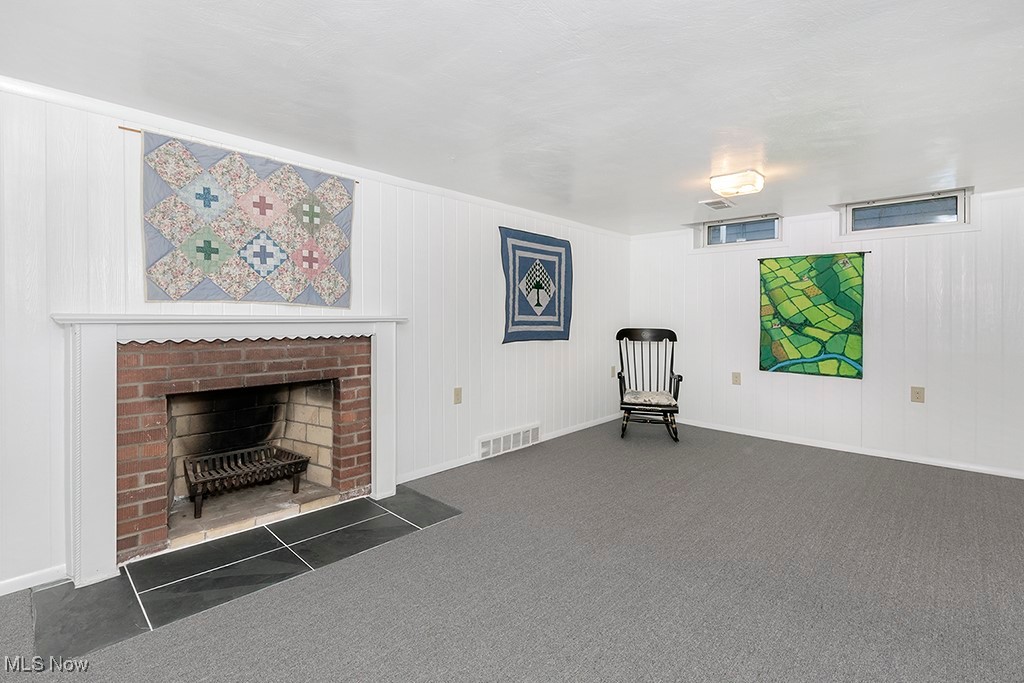 14711 South Woodland Road Cleveland, OH 44120 - Photo 25 of 31 The Lower Level is Reached from a Stairway Off the Kitchen and Garage Entry. A Full-Sized Recreation Room with a Wood-Burning Fireplace has been Updated with Beadboard Half-Paneling and Wall-to-Wall Carpeting.