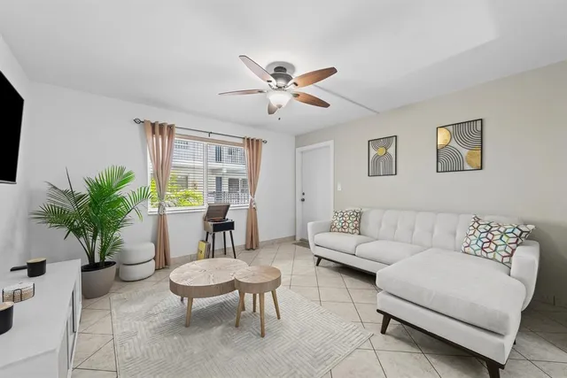 a living room with furniture potted plant and window