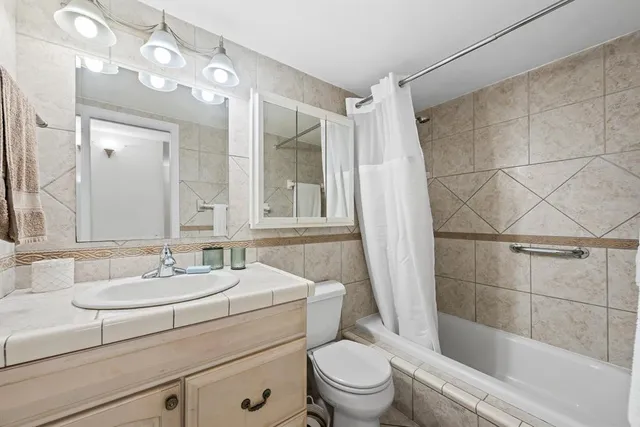 a bathroom with a sink toilet a mirror and shower