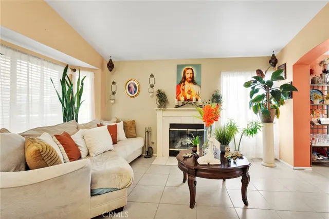 a living room with furniture a fireplace and a large window