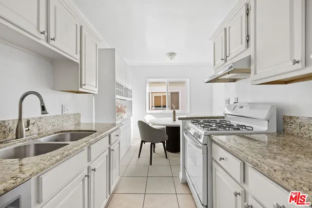 a kitchen with stainless steel appliances granite countertop a sink stove and cabinets
