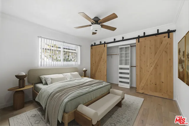 a bedroom with a large bed and a ceiling fan