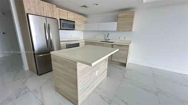 a kitchen with stainless steel appliances a refrigerator sink and microwave