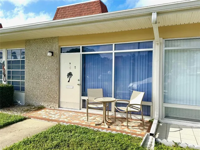 a chair and table in front of a house