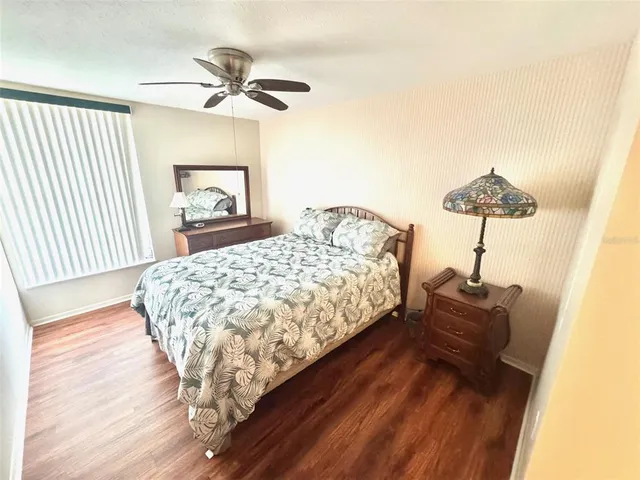 a bed sitting in a bedroom next to a window and a chandelier