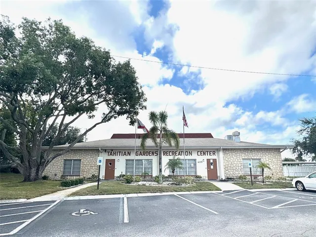 a front view of a building with street view and trees