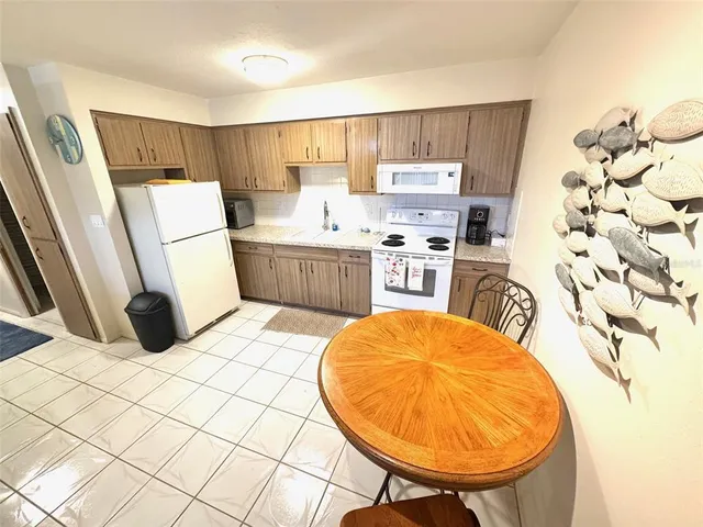 a kitchen with stainless steel appliances a stove a sink a microwave a refrigerator and cabinets