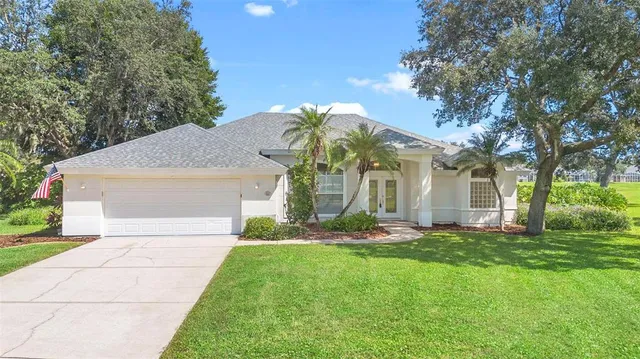 a front view of a house with a yard and trees
