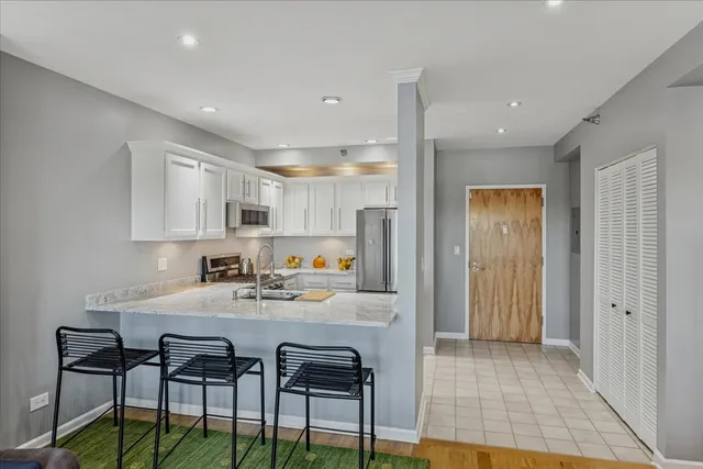 a kitchen with stainless steel appliances granite countertop a stove a sink a dining table and chairs