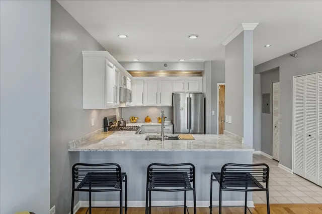 a kitchen with stainless steel appliances granite countertop a sink and a refrigerator