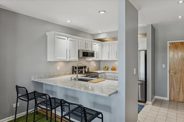 a kitchen with stainless steel appliances a sink a stove a refrigerator and cabinets