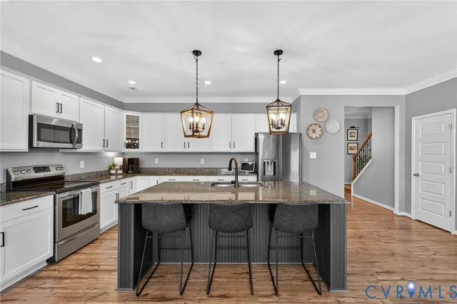 a kitchen with a dining table chairs stainless steel appliances and cabinets