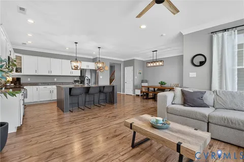 a living room kitchen with furniture and a wooden floor