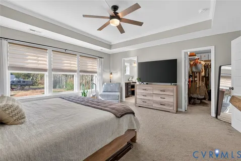 a bedroom with bed tv and window