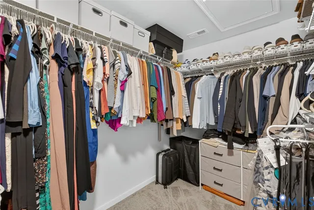 a view of walk in closet with clothes