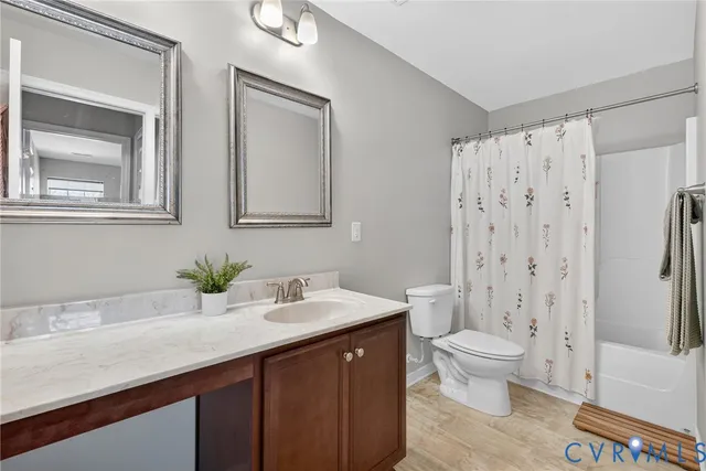 a spacious bathroom with a granite countertop sink toilet and shower