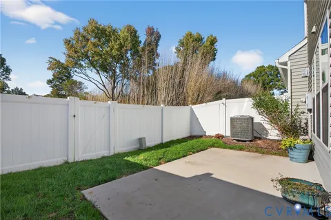 a view of a white house with a yard and potted plants