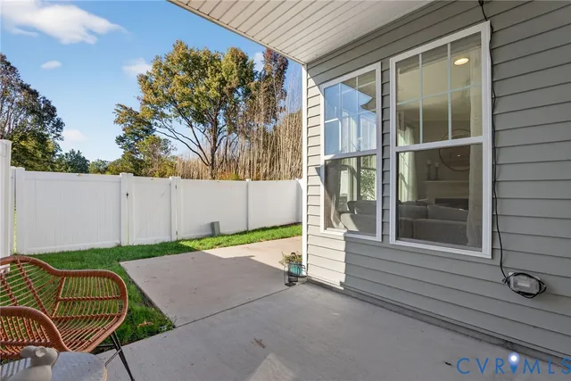 a view of backyard with seating space and wooden fence
