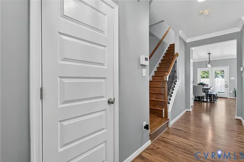 a view of a hallway with wooden floor and staircase