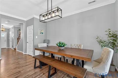 a view of a dining room with furniture wooden floor and a chandelier