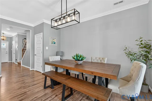 a view of a dining room with furniture wooden floor and a chandelier